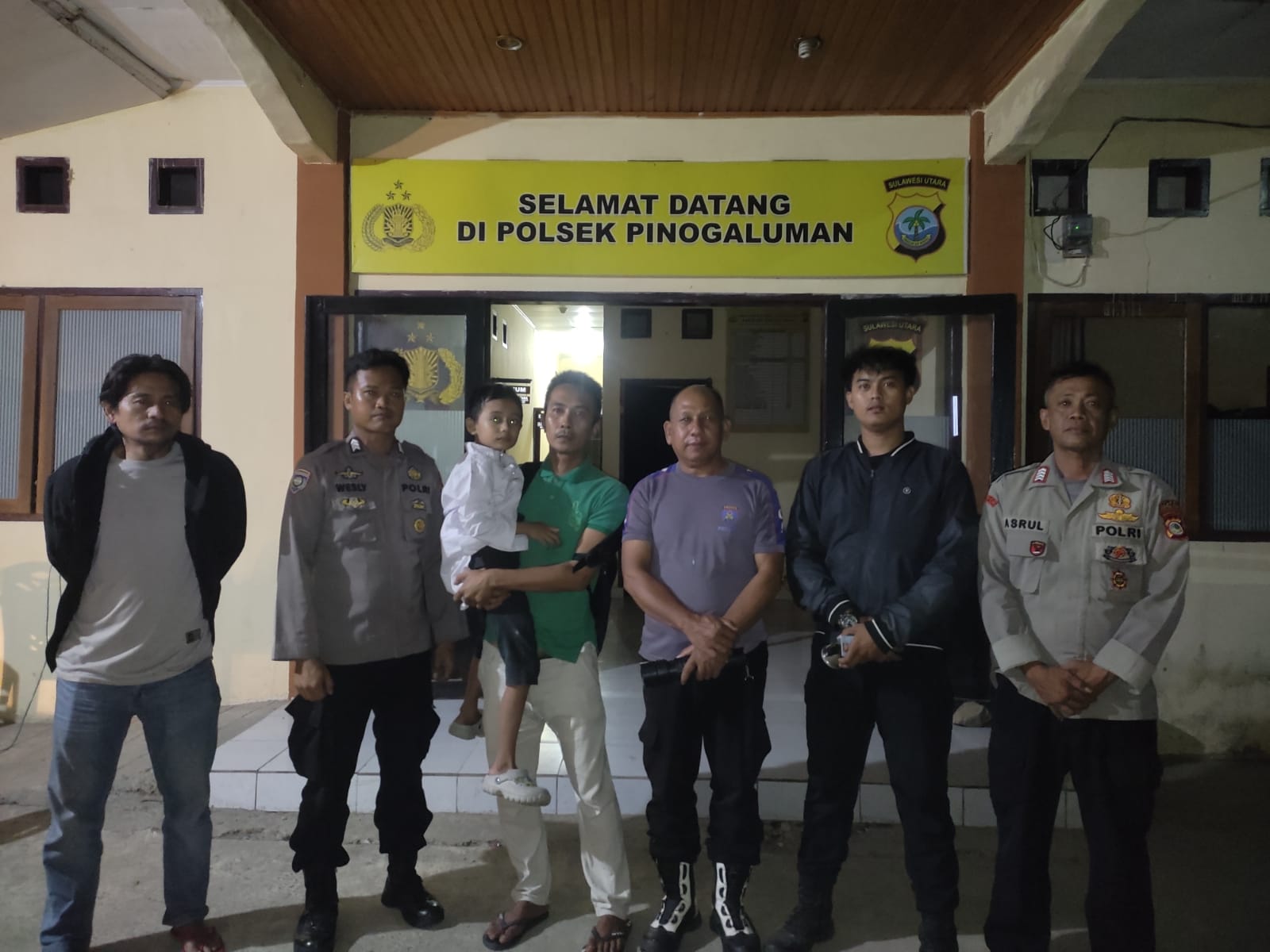 Personel Polsek Pinogaluman menunjukkan anak yang berhasil ditemukan dalam kondisi sehat, Minggu (5/7/2026) dini hari.
